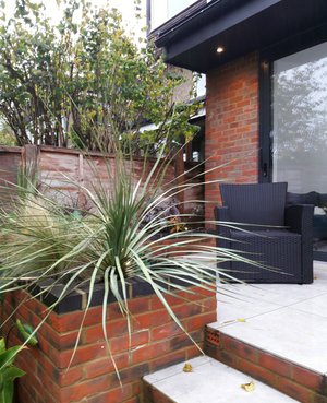 Brick and zinc extension to house in Watford. Brick planters with tropical planting.